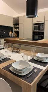 a kitchen with a table with white plates and glasses at MEET - AIRBUS - TRAMWAY in Aussonne