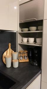 a kitchen counter with white bowls and plates on it at MEET - AIRBUS - TRAMWAY in Aussonne