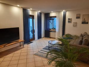a living room with a couch and a flat screen tv at Ferienwohnung Sophie - perfekt mit Kind und Kegel in Eitelborn