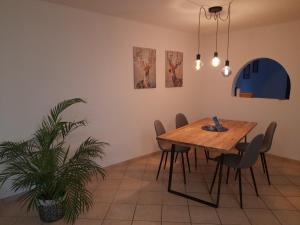 a dining room with a table and chairs and a plant at Ferienwohnung Sophie - perfekt mit Kind und Kegel in Eitelborn