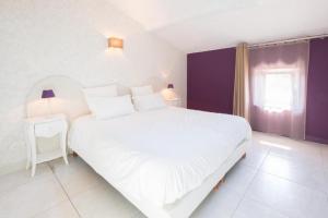 Un dormitorio con una gran cama blanca y una ventana en Coeur de Vignes en Saint-Péray