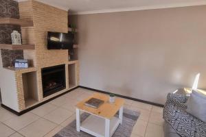 un soggiorno con divano e camino di Spacious Cottage a Mount Road
