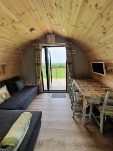 オークニー諸島にあるLilly's Lodges Orkney Robin Lodgeのソファとテーブルが備わる客室です。