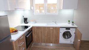 uma cozinha com uma máquina de lavar roupa e um lavatório em Cozy apartment near the city centre em Iráclio