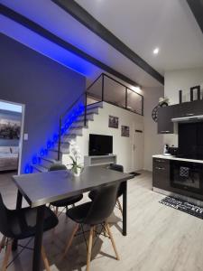 une salle à manger avec un escalier à éclairage bleu dans l'établissement Loft and Studio and Love Room, à Bourg-Saint-Christophe