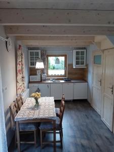 a kitchen with a table and chairs and a sink at Domek Na Leśnym Wzgórzu in Pieszyce