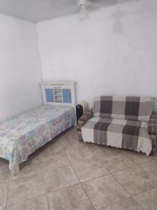 1 Schlafzimmer mit 2 Betten und Fliesenboden in der Unterkunft Casa para temporada em Rio das Ostras in Rio das Ostras