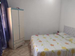 ein Schlafzimmer mit einem Bett und einer Kommode in einem Zimmer in der Unterkunft Casa para temporada em Rio das Ostras in Rio das Ostras