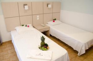 duas camas num quarto com uma tigela de fruta em Athos Hotel em Nydri
