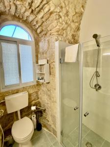 a bathroom with a toilet and a glass shower at Christian Quarter Studio I in Jerusalem