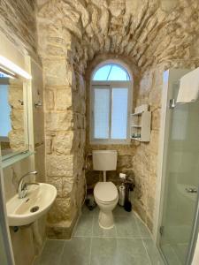 a stone bathroom with a toilet and a sink at Christian Quarter Studio I in Jerusalem