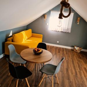 a living room with a yellow couch and a table at Apartament w Jałowcach in Gronków