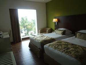 Postel nebo postele na pokoji v ubytování Ramee Grand Hotel and Spa, Pune