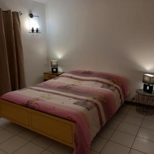 a bedroom with a bed with a pink comforter at Villa Cara, 6 personnes, proche plage et commerces, secteur calme, Classé 3 étoiles in Le Barcarès