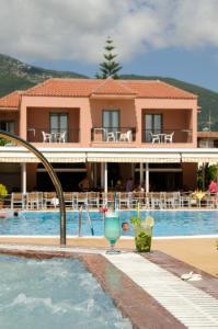 a resort with a swimming pool and a building at Athos Hotel in Nydri