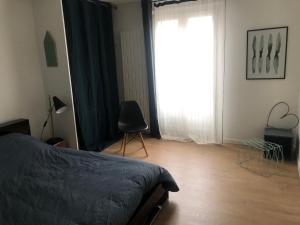 ein Schlafzimmer mit einem Bett und einem großen Fenster in der Unterkunft Le Spot, appartement spacieux à 30m de la mer 45m2 in Luc-sur-Mer