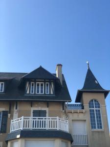 ein Haus mit einem Turm und einem Balkon in der Unterkunft Le Spot, appartement spacieux à 30m de la mer 45m2 in Luc-sur-Mer