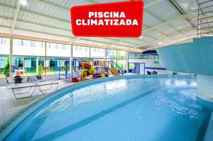 a swimming pool in a building with a sign at Hotel Golden Park Sorocaba & Convenções by Nacional Inn in Sorocaba