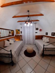 a living room with two beds and a chandelier at La Tavernetta in Pignola