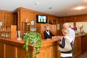 a man and a woman standing at a bar at Hotel Ristorante Walser in Bosco Gurin