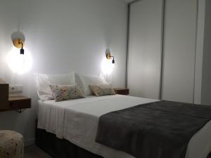 een slaapkamer met een groot bed met 2 kussens bij Henriqueta Maia Suits in Ílhavo