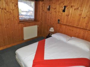 sypialnia z łóżkiem z czerwonym kocem w obiekcie Chalet 2 Le Méridien Les Gets w mieście Les Gets