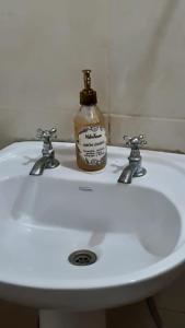 a bottle of soap sitting on top of a bathroom sink at Posada Mis Padres in Godoy Cruz +28 photos