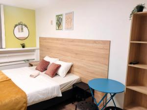 um pequeno quarto com uma cama e uma mesa azul em Гостиница City House em Yaroslavl