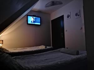 sypialnia z dwoma łóżkami i telewizorem na ścianie w obiekcie RESTAURACJA & PENSJONAT SZAMANKO w mieście Hrubieszów