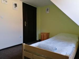 1 dormitorio con cama y puerta negra en RESTAURACJA & PENSJONAT SZAMANKO en Hrubieszów