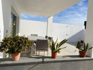 patio ze stołem, krzesłami i doniczkami w obiekcie Casa de Playa maravillosa en Taliarte w mieście Las Palmas de Gran Canaria