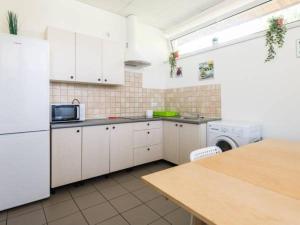 a kitchen with white cabinets and a washer and dryer at Pokoje Tanie Spanie in Zator