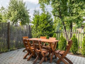 a wooden table with four chairs and a fence at Pokoje Tanie Spanie in Zator