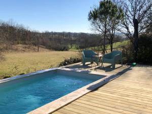 a pool with two chairs and a table on a deck at Bellevue in Saint-Paul-Lizonne
