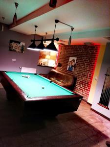 a pool table in a room with a brick wall at RESTAURACJA & PENSJONAT SZAMANKO in Hrubieszów