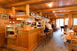 een groep mensen die aan een bar in een restaurant zitten bij Hotel Ristorante Walser in Bosco Gurin