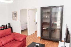 salon z czerwoną kanapą i telewizorem w obiekcie Apartamento Alexa, a 800mts Catedral WiFi Smart TV w Murcji