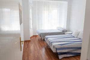 sypialnia z dwoma łóżkami i oknem w obiekcie Apartamento Alexa, a 800mts Catedral WiFi Smart TV w Murcji