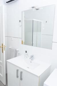 Baño blanco con lavabo y espejo en Apartamento Alexa, a 800mts Catedral WiFi Smart TV, en Murcia