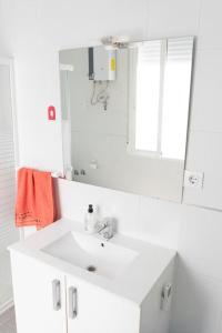 biała łazienka z umywalką i lustrem w obiekcie Apartamento Alexa, a 800mts Catedral WiFi Smart TV w Murcji