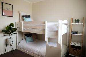 a white bunk bed in a room at Sunshine Coast Beach House - 2 mins to beach in Parrearra