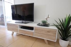a television on a white entertainment center in a living room at Sunshine Coast Beach House - 2 mins to beach in Parrearra