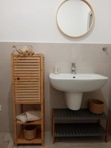 bagno con lavandino e specchio a parete di Scialè Salento Casa Vacanza a Lido Conchiglia