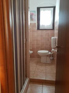 uma casa de banho com um WC e uma janela em Casa Lorica M&S em Lorica