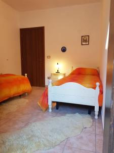 a bedroom with two beds with orange sheets at Casa Lorica M&S in Lorica