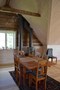 a wooden table and chairs in a room with a stove at Sjöbredareds Gård in Hökerum