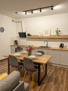 a kitchen with a wooden table with chairs and a kitchen at Przytulny Apartament Mickiewicza 14/3 in Wieleń