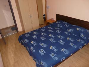 ein Bett mit blauer Decke in einem Schlafzimmer in der Unterkunft Family Hotel Balchik in Baltschik + 18 Fotos