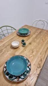 un tavolo di legno con due piastre blu sopra di Scialè Salento Casa Vacanza a Lido Conchiglia