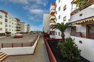a balcony of a building with a palm tree at Luxury 3 bedroom Perla Del Mar in Adeje